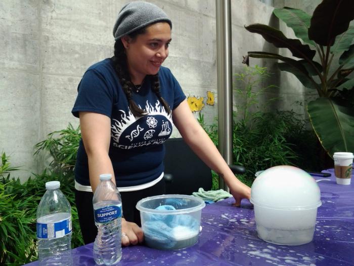 Sasha Amadore, a science dome coordinator teaches about Pluto's atmosphere.