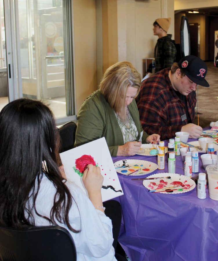 Theo Deo paints a beautiful rose, while Allie Morrow paints rocks, and Will Syhlman paints a canvas.