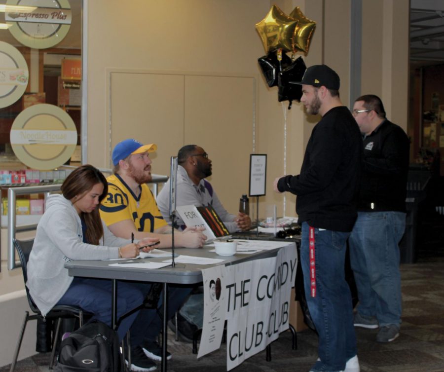 Nathan DiCarlo (member of The Comedy Club-Club) and Frederick Taylor (President of Students of Color Empowerment Group) talk with students about their clubs. Raisa Santos also sits at the table.