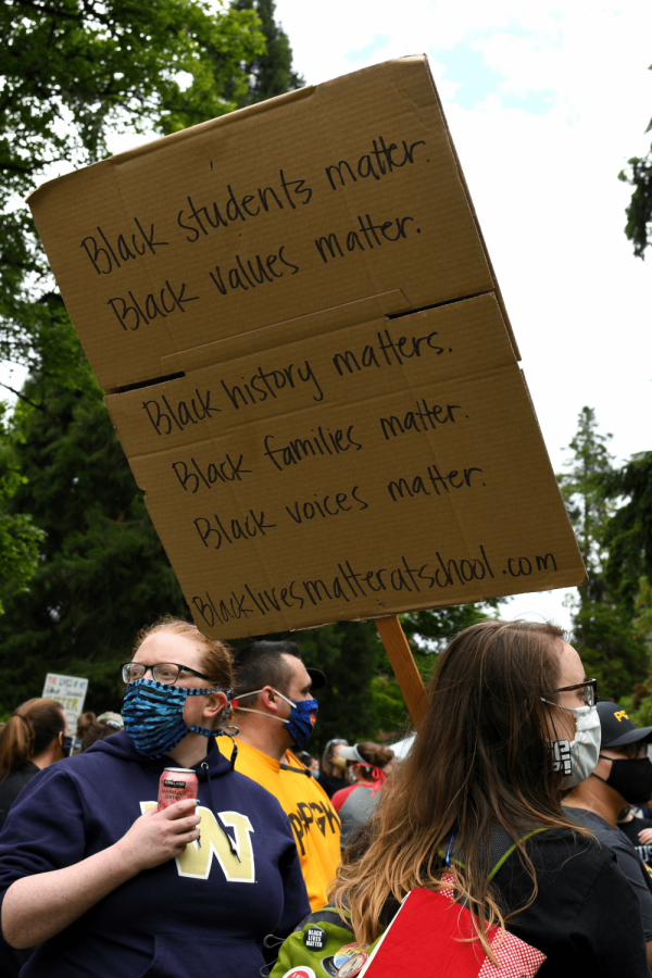 A woman carrying her sign through the audience.